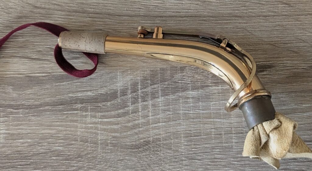 A pull through being pulled through the neck of an alto saxophone.
